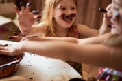 Kinder spielen in der Küche und haben ein mit Schokolade verschmiertes Gesicht. Kinder spielen in der Küche und haben ein mit Schokolade verschmiertes Gesicht.